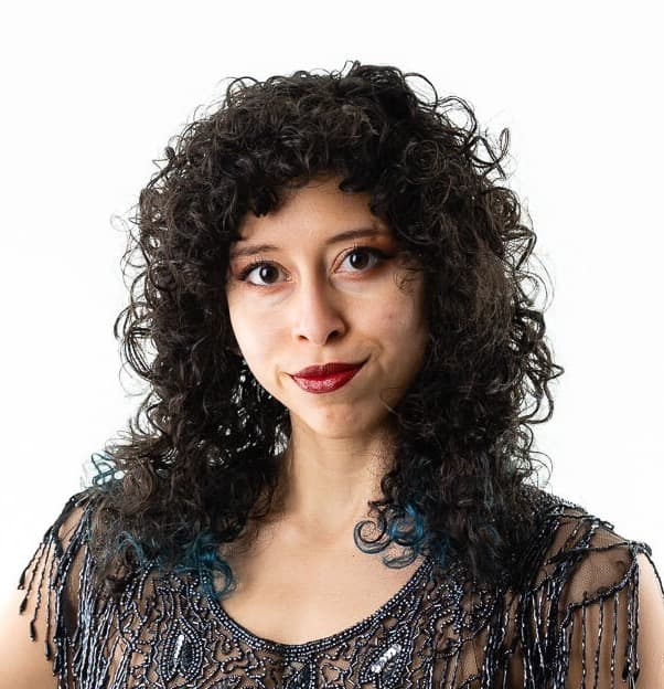 Gabby smiling and hanging from aerial silks