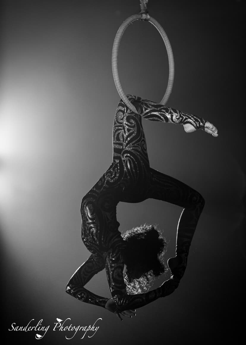 Gabby doing a single knee hang on aerial mini hoop